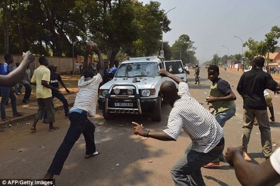 Brutal: Kerumunan orang sedang melempari sebuah mobil yang membawa dua anak dari mantan Kolonel tentara Seleka di perbatasan zona perlindungan PBB di Bangui pada hari Ahad (16/2).